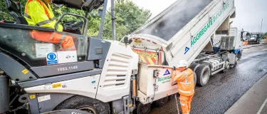 Two of the Aggregate Industries Surfacing Solutions team resurfacing a road with machinery