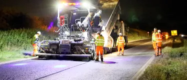 Workers laying asphalt on the A46 at night