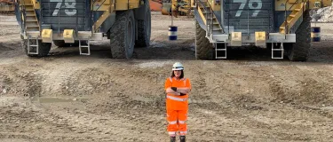 Dump truck driver Elinore Smith at Glensanda Quarry in front of two 100-tonne rigid dump trucks.