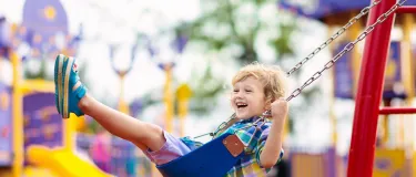 Young boy on a swing in a playpark