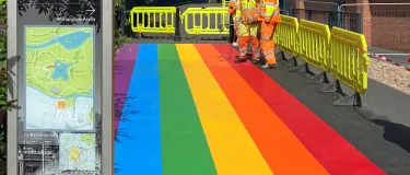 Workmen in high viz using blow torches as they lay the rainbow coloured pathway for Leicester Pride