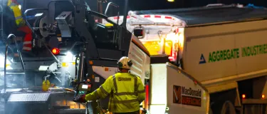 Banner image showing aggregate industries truck pouring asphalt into a paver