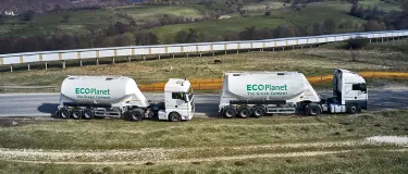 Two cement tankers with the Ecoplanet green cement logo on the side driving through the countryside