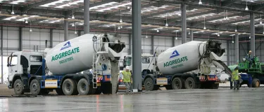 Two Aggregate Industries Concrete Mixing Trucks pump readymix concrete onto the site of Longhill Burn Wind Turbine project in Scotland