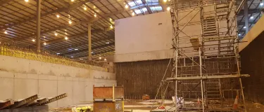 Inside a large building with demolished material and concrete