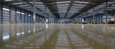 Newly constructed empty warehouse with wet screed on the floor