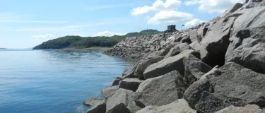 Armourstone on a coastline with a castle in the background