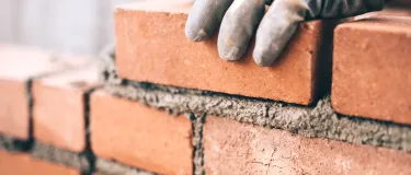 Close up of bricks being laid using bagged cement