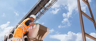 A worker in high visibility clothing checks a mixer truck