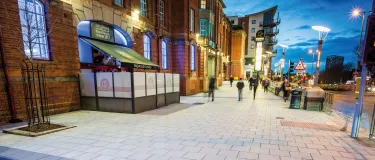 The broadway plaza at night time with people walking on pavement