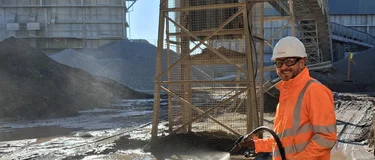 Managing Director of Aspahlt, Danny King, in high viz PPE jetwashing at Bardon Hill asphalt plant
