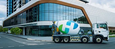 Holcim cement mixer in front of the corner of a building