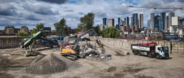 London skyline with Holcim branded excavator, conveyor and truck with aggregates