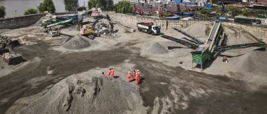 An aerial shot of Holcim's Morden Wharf Recycling Centre in London with the River Thames and the City of London in the background