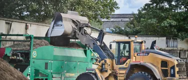 Soil transferring into a grading machine from a mechanical shovel