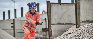 A female worker in high visibility PPE handles construction demolition materials at Holcim Land Recovery's Bordesley Green Recycling Centre