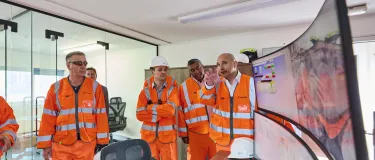 Adam Kutcher, right, demonstrates the control room at Holcim's London Bow plant