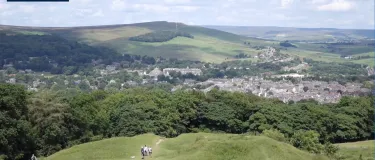 peak cluster logo in top left with a vista of rolling hills, a small town and blue skys