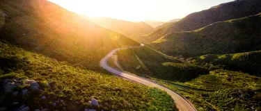 Road through a green valley during the golden hour