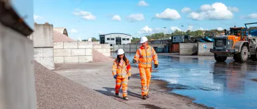 Rob Walsh in high viz PPE walking through the Land Recovery site in Stoke with colleague Sonia Martinez.