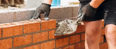 Man laying bricks on a wall