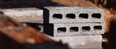 Breeze blocks stacked in a muddy environment 