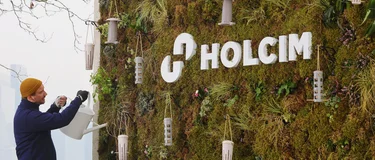 A worker waters a sustainable billboard on London's South bank. The billboard was created for the rebrand to Holcim UK.