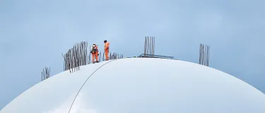 Workers in PPE working on top of Tilbury Cement Terminal dome roof