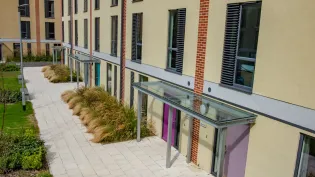 An image of Charcon's homebuilder flag in buff laid outside an apartment block