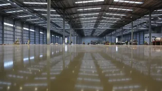 Newly constructed empty warehouse with wet screed on the floor