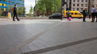 Vianova hard landscaping in city centre with people and traffic in background