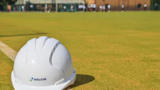 A Holcim hard hat sits on the newly refurbish artificial pitch at St Benedict School in Derby. Holcim UK donated specialist sports sand to the project.