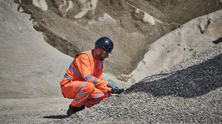 A colleague in high viz takes a closer look at the construction demolition materials processed at Holcim's Morden Wharf Recycling Centre in London.