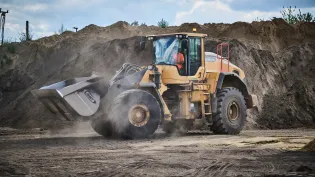 Loading Shovel moving through piles of soil