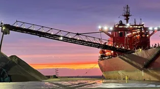 The MV Yeoman Bridge dispensing aggregates delivered by sea to a portside wharf