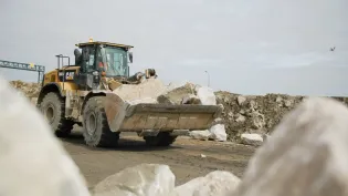 A mechanical loading shovel carries granite boulders delivered from Glensanda Super Quarry to bolster Stallingborough's coastal sea defences