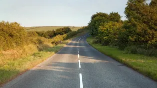 Country road at golden hour with surface dressing chippings on it