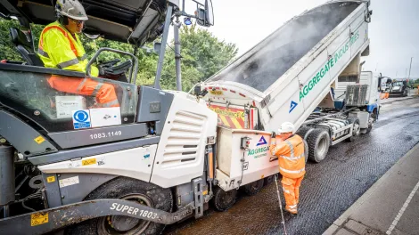 Two of the Aggregate Industries Surfacing Solutions team resurfacing a road with machinery