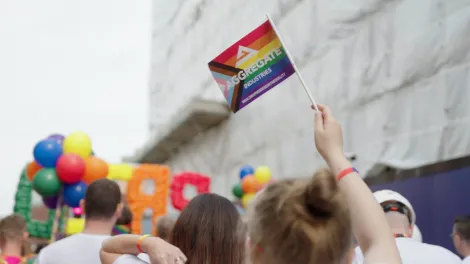 An Aggregate Industries Pride flag in rainbow colours being waved at Leicester's Pride parade in 2022