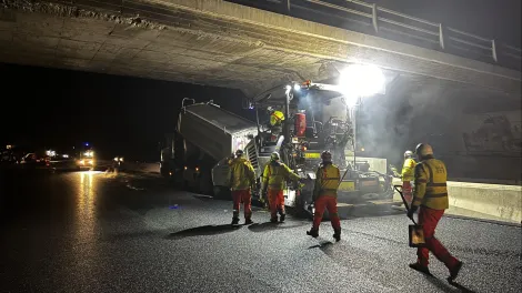Laying Warm Mix Asphalt on the M1 under a bridge