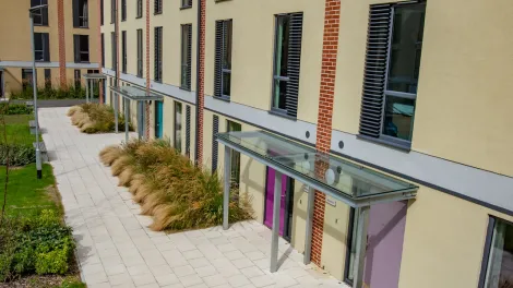 An image of Charcon's homebuilder flag in buff laid outside an apartment block