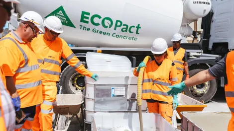 Foam concrete Airium Voidfill and Airium Roadfill is launched in the UK. An operative in high vis clothing is pumping the product from the mixer truck into a tub while colleagues watch on.