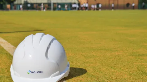 A Holcim hard hat sits on the newly refurbish artificial pitch at St Benedict School in Derby. Holcim UK donated specialist sports sand to the project.