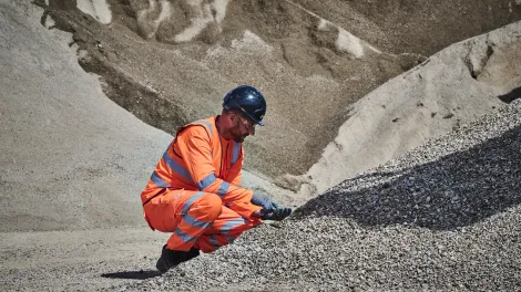 A colleague in high viz takes a closer look at the construction demolition materials processed at Holcim's Morden Wharf Recycling Centre in London.