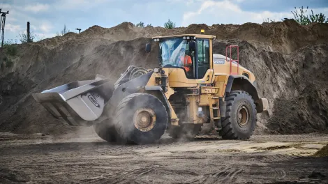 Loading Shovel moving through piles of soil
