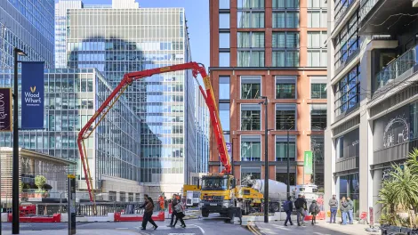 A truck with an extended arm pumping biochar coffee concrete to support the Whale on the Wharf scultpure in Canary Wharf.