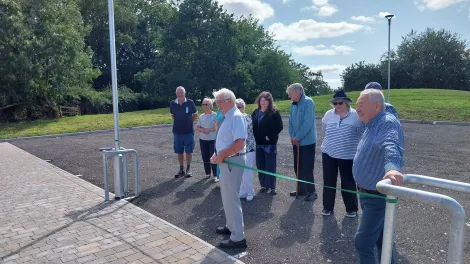 a group of people inspecting a newly built carpark outside