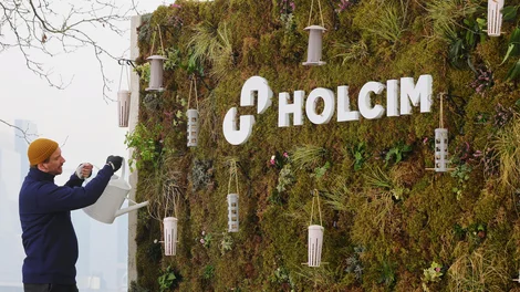 A worker waters a sustainable billboard on London's South bank. The billboard was created for the rebrand to Holcim UK.