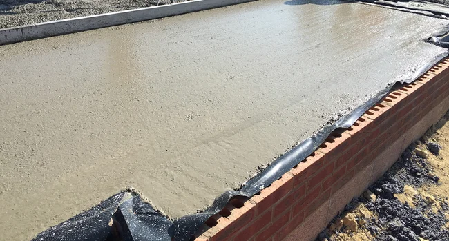 Fibre reinforced pavement grade concrete poured for residential housing road foundation.