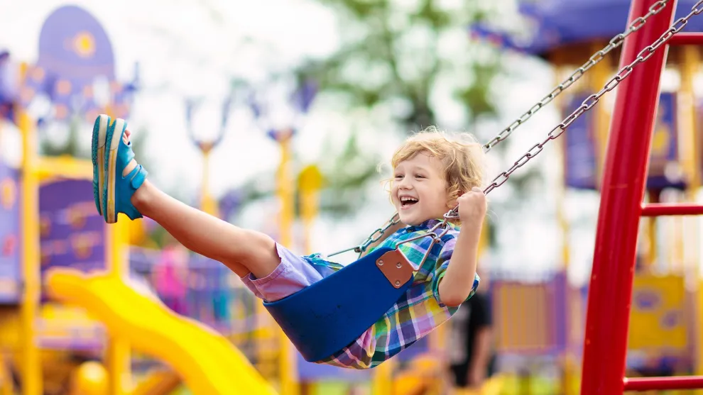Young boy on a swing in a playpark